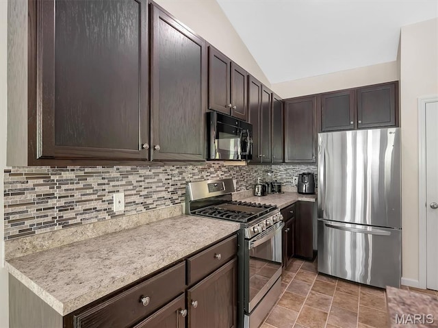 1109 Foxwood Estates Dr, Arnold, MO 63010 - kitchen featuring appliances with stainless steel finishes, dark brown cabinets, light countertops, lofted ceiling, and backsplash