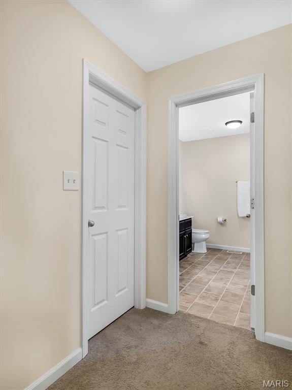 1109 Foxwood Estates Dr, Arnold, MO 63010 - hall with light colored carpet, baseboards, and light tile patterned flooring