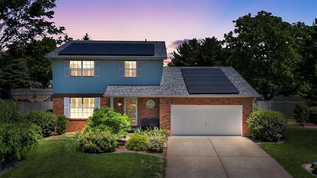1102 Affirm Dr, Ofallon, IL 62269 - traditional-style home featuring roof mounted solar panels, brick siding, an attached garage, and driveway