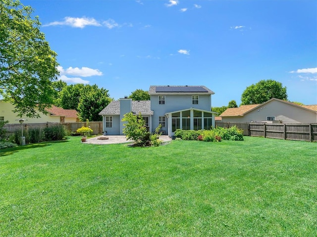 1102 Affirm Dr, Ofallon, IL 62269 - back of house with a patio, roof mounted solar panels, a sunroom, and a chimney