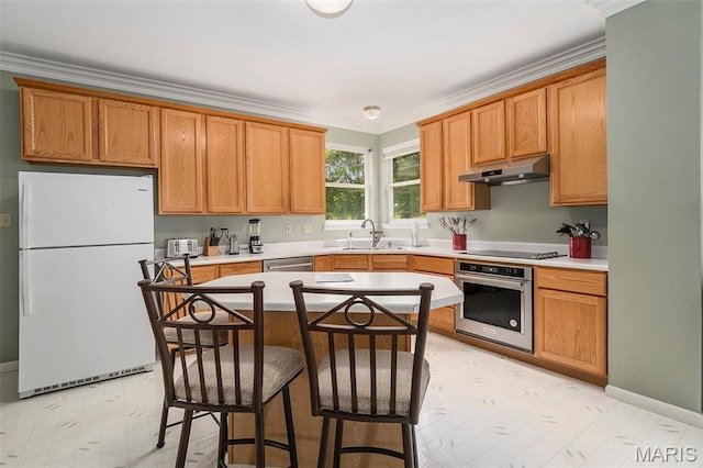 1575 Uthoff Dr, Fenton, MO 63026 - kitchen featuring stainless steel appliances, under cabinet range hood, a breakfast bar area, light countertops, and crown molding