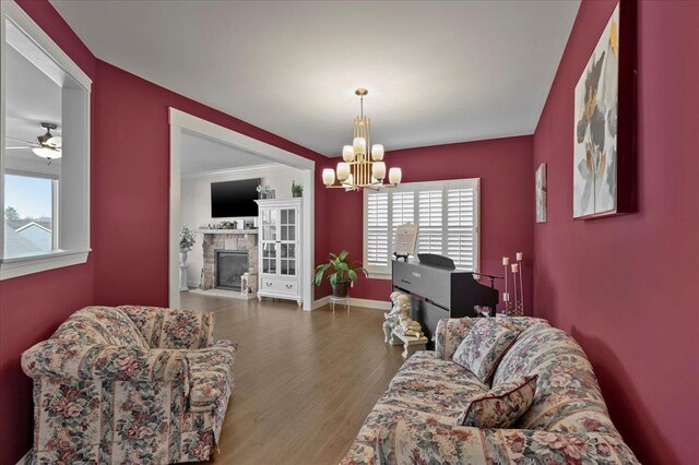 1355 Bloomfield Dr, Eureka, MO 63025 - living room featuring a chandelier, wood finished floors, a glass covered fireplace, and baseboards