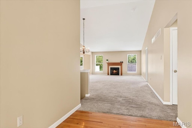 1423 Villas Estates Dr, Saint Louis, MO 63026 - hallway with a chandelier, light carpet, light wood-type flooring, and high vaulted ceiling