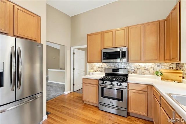 1423 Villas Estates Dr, Saint Louis, MO 63026 - kitchen featuring appliances with stainless steel finishes, tasteful backsplash, light wood-type flooring, light countertops, and light brown cabinetry