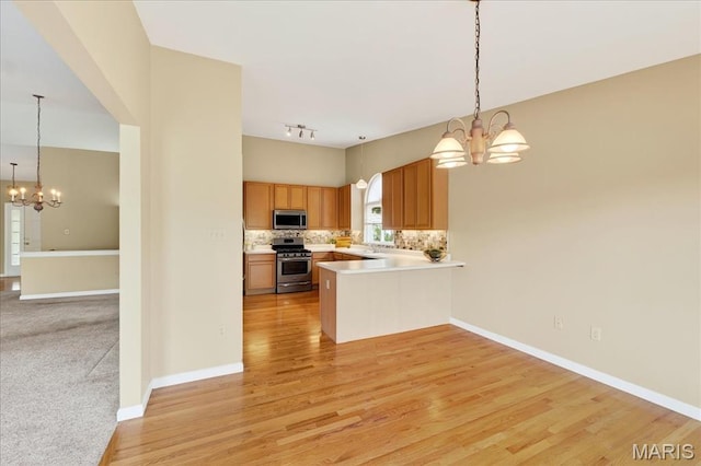 1423 Villas Estates Dr, Saint Louis, MO 63026 - kitchen featuring appliances with stainless steel finishes, a chandelier, tasteful backsplash, and light countertops