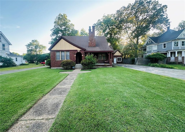 417 S Kingshighway St, Sikeston, MO 63801 - view of front of home featuring brick siding, a chimney, a front lawn, covered porch, and driveway