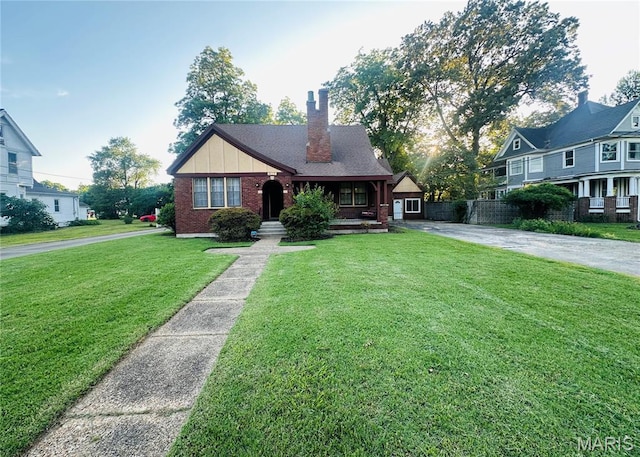 417 S Kingshighway St, Sikeston, MO 63801 - view of front of house with brick siding, a chimney, a front yard, a porch, and driveway