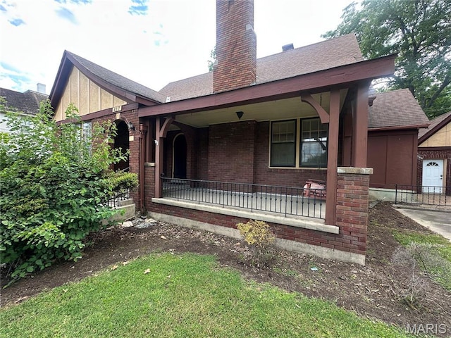 417 S Kingshighway St, Sikeston, MO 63801 - view of front facade featuring brick siding, a porch, a chimney, and roof with shingles