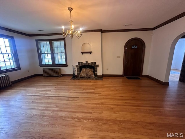 417 S Kingshighway St, Sikeston, MO 63801 - unfurnished living room featuring radiator heating unit, arched walkways, a chandelier, ornamental molding, and wood finished floors