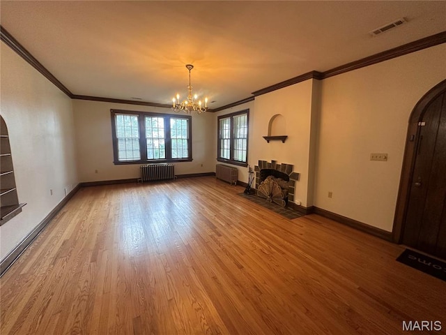 417 S Kingshighway St, Sikeston, MO 63801 - unfurnished living room featuring radiator, arched walkways, crown molding, a chandelier, and wood finished floors