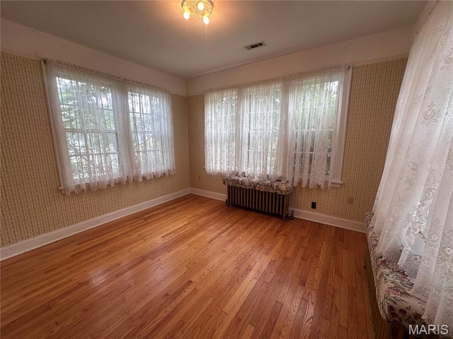 417 S Kingshighway St, Sikeston, MO 63801 - unfurnished room with radiator heating unit, wood finished floors, and wallpapered walls