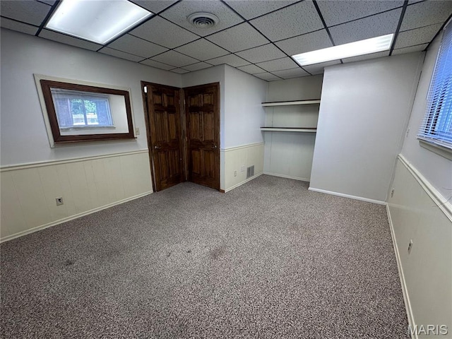 417 S Kingshighway St, Sikeston, MO 63801 - unfurnished bedroom featuring wainscoting, a drop ceiling, multiple windows, and carpet