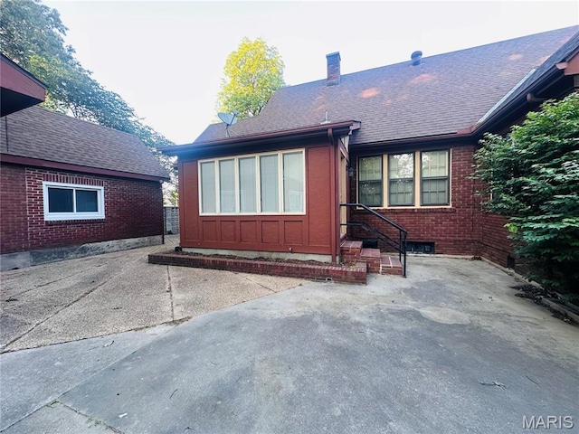 417 S Kingshighway St, Sikeston, MO 63801 - back of property featuring a chimney, a patio, brick siding, and roof with shingles