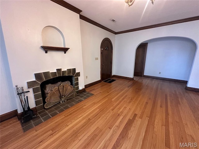 417 S Kingshighway St, Sikeston, MO 63801 - living room featuring arched walkways, ornamental molding, wood finished floors, and a tiled fireplace