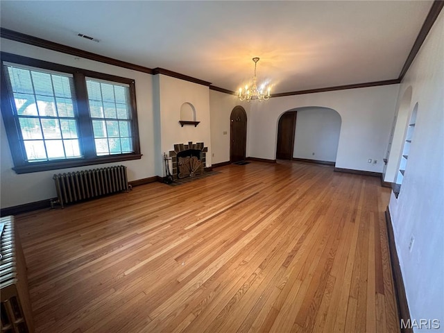 417 S Kingshighway St, Sikeston, MO 63801 - unfurnished living room with radiator, arched walkways, hardwood / wood-style flooring, a chandelier, and ornamental molding