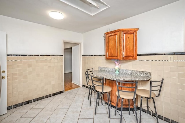 12810 Big Bend Rd, Kirkwood, MO 63122 - dining area with tile walls, light tile patterned floors, and a wainscoted wall