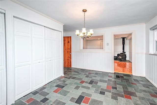 12810 Big Bend Rd, Kirkwood, MO 63122 - unfurnished dining area with a chandelier, wainscoting, a wood stove, and crown molding
