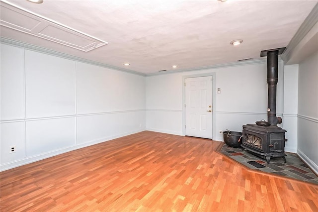 12810 Big Bend Rd, Kirkwood, MO 63122 - basement with a wood stove, light wood-type flooring, recessed lighting, ornamental molding, and baseboards