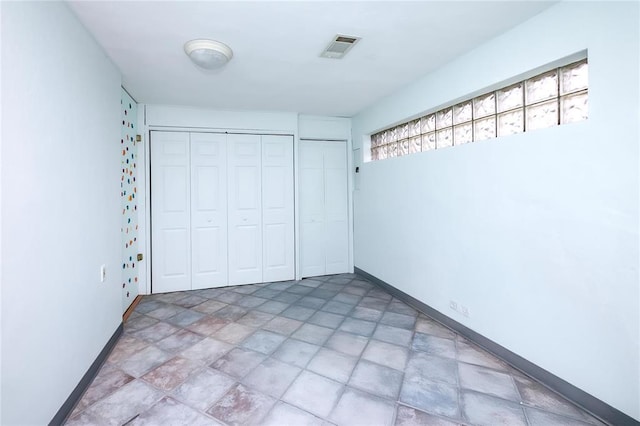 12810 Big Bend Rd, Kirkwood, MO 63122 - unfurnished bedroom featuring stone finish floors, a closet, and baseboards