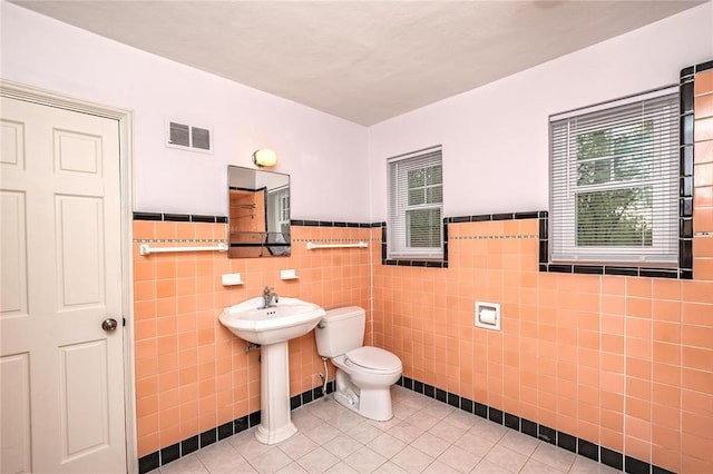 12810 Big Bend Rd, Kirkwood, MO 63122 - bathroom with toilet, tile patterned flooring, tile walls, a wainscoted wall, and a sink