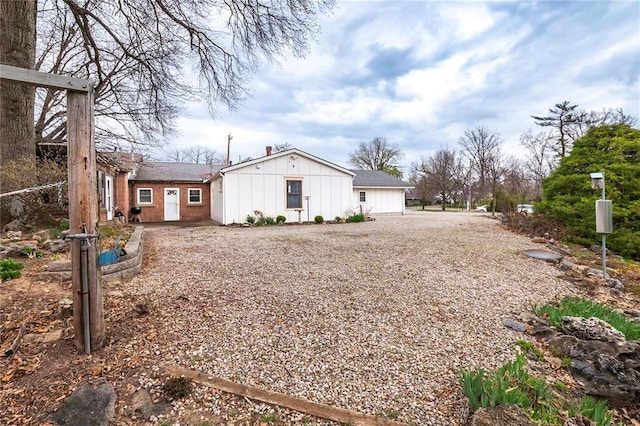 12810 Big Bend Rd, Kirkwood, MO 63122 - view of side of home featuring board and batten siding, driveway, and a chimney