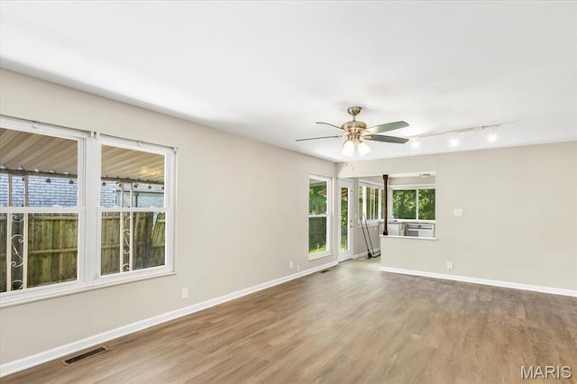 3368 S Suncrest Ave, Saint Louis, MO 63114 - spare room with rail lighting, wood finished floors, and ceiling fan