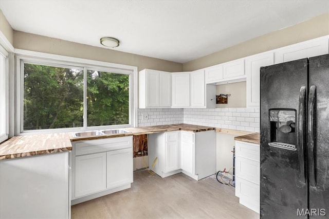 3368 S Suncrest Ave, Saint Louis, MO 63114 - kitchen with black fridge with ice dispenser, backsplash, white cabinets, light wood-style floors, and wooden counters