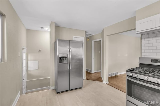 3368 S Suncrest Ave, Saint Louis, MO 63114 - kitchen featuring stainless steel appliances, light wood-style floors, white cabinets, and tasteful backsplash