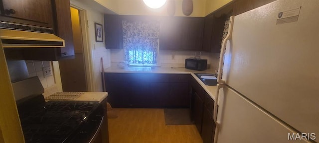 4209 Edgewood Blvd, Normandy, MO 63121 - kitchen featuring freestanding refrigerator, gas range, decorative backsplash, a sink, and black microwave
