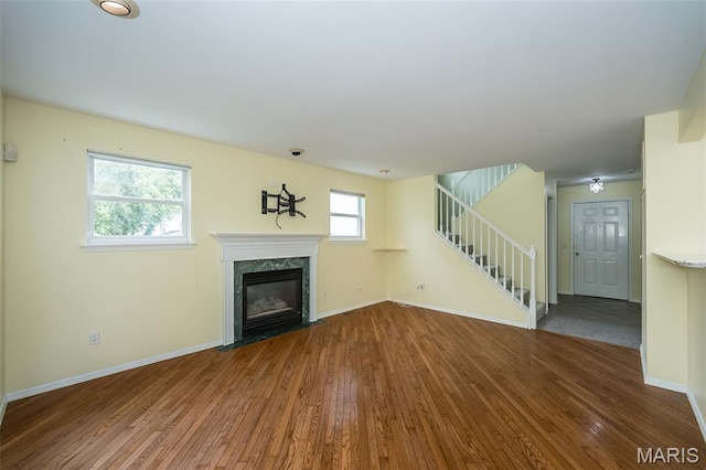 1105 Big Bend Crossing Dr, Manchester, MO 63088 - unfurnished living room featuring wood finished floors, stairs, a fireplace, and baseboards