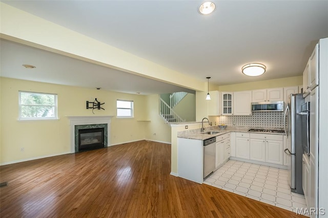 1105 Big Bend Crossing Dr, Manchester, MO 63088 - kitchen with stainless steel appliances, open floor plan, a sink, a peninsula, and tasteful backsplash
