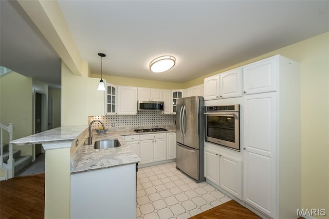 1105 Big Bend Crossing Dr, Manchester, MO 63088 - kitchen with stainless steel appliances, a peninsula, a sink, glass insert cabinets, and white cabinetry