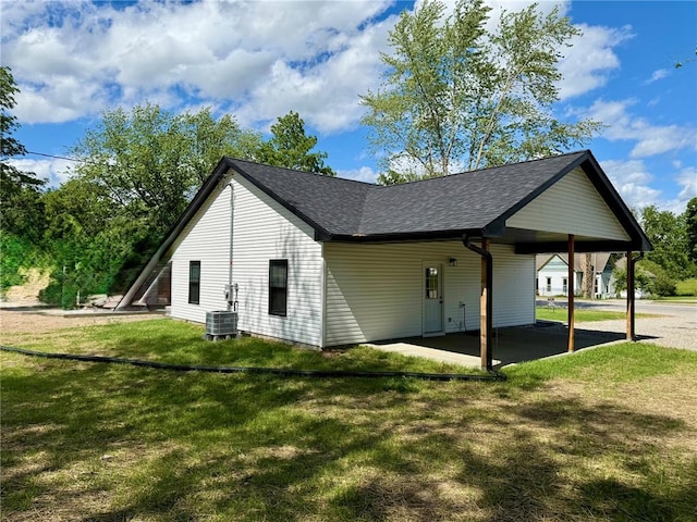812 Main St, New London, MO 63459 - view of home's exterior featuring a carport, a lawn, a shingled roof, a patio area, and cooling unit