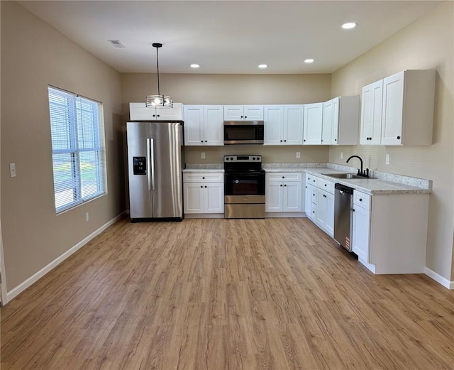812 Main St, New London, MO 63459 - kitchen featuring stainless steel appliances, a sink, light countertops, baseboards, and light wood-style flooring