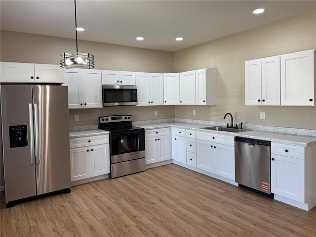 812 Main St, New London, MO 63459 - kitchen with stainless steel appliances, a sink, white cabinetry, light wood-style floors, and recessed lighting