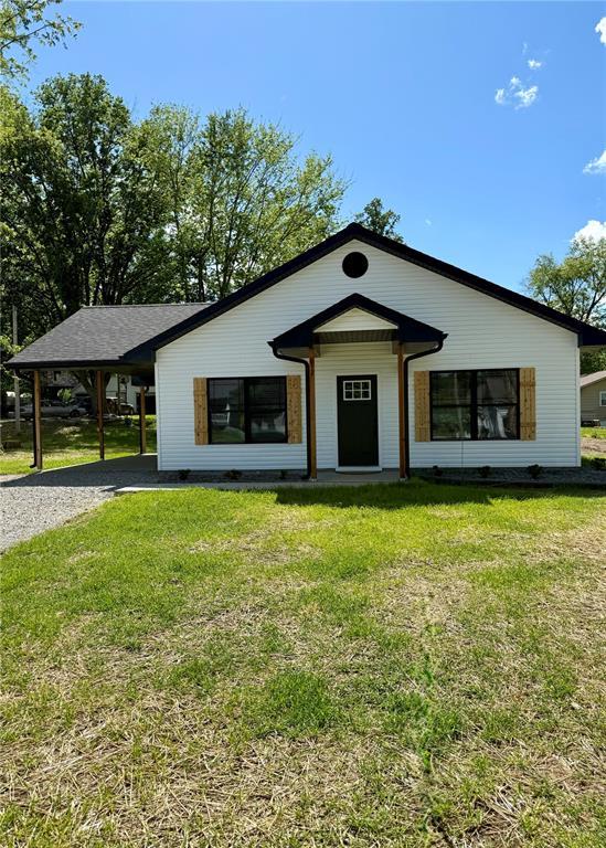 812 Main St, New London, MO 63459 - view of front of home with driveway, a carport, and a front yard