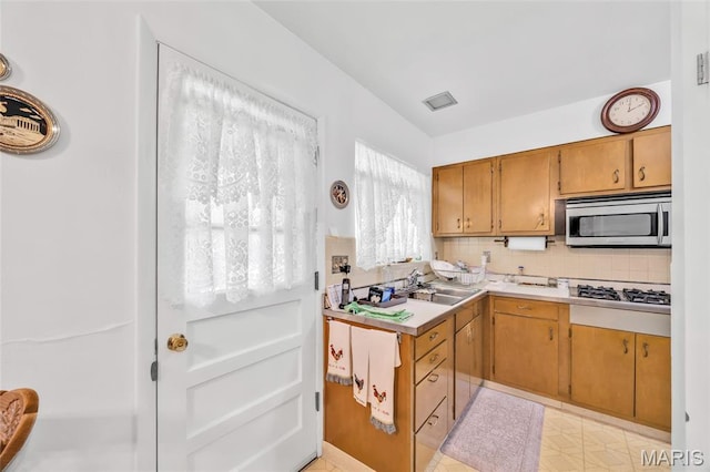 8967 New Sappington Rd, Crestwood, MO 63126 - kitchen featuring stainless steel appliances, a sink, light countertops, backsplash, and brown cabinets
