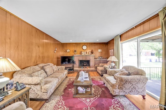 8967 New Sappington Rd, Crestwood, MO 63126 - living room featuring wood finished floors, wooden walls, and a brick fireplace
