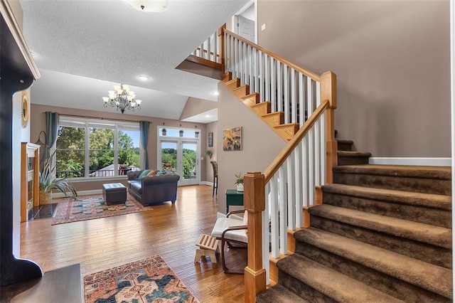 1014 Trailridge Dr, Jackson, MO 63755 - stairway featuring wood finished floors, baseboards, a chandelier, and a textured ceiling