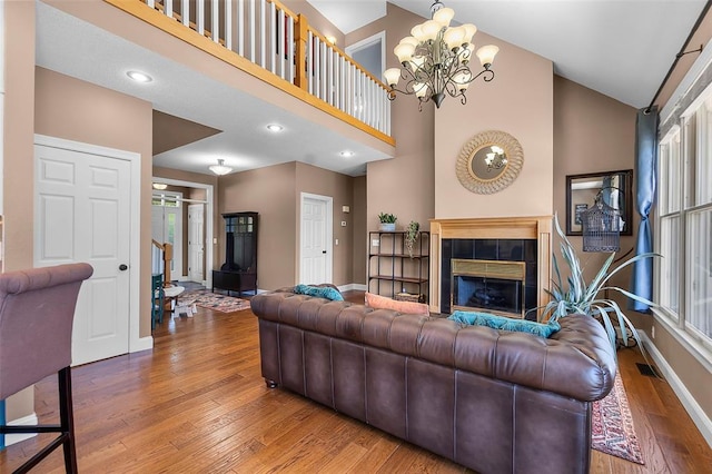 1014 Trailridge Dr, Jackson, MO 63755 - living area with baseboards, wood finished floors, high vaulted ceiling, a chandelier, and a tile fireplace