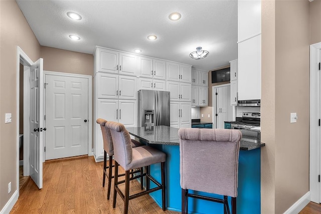 1014 Trailridge Dr, Jackson, MO 63755 - kitchen featuring stainless steel appliances, white cabinets, a peninsula, light wood-style flooring, and baseboards