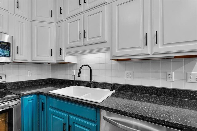1014 Trailridge Dr, Jackson, MO 63755 - kitchen featuring stainless steel appliances, white cabinetry, a sink, tasteful backsplash, and blue cabinets