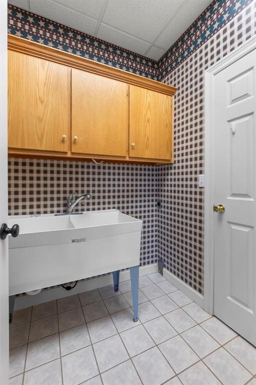1014 Trailridge Dr, Jackson, MO 63755 - washroom with wallpapered walls, cabinet space, light tile patterned floors, and baseboards