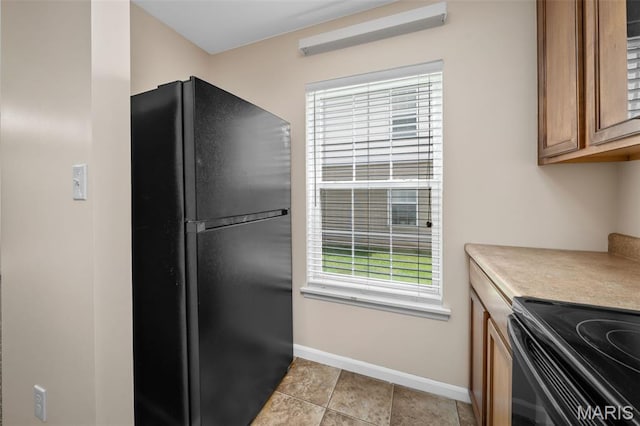 160 Brandy Mill Cir Unit 7C, High Ridge, MO 63049 - kitchen featuring black appliances, brown cabinetry, light countertops, and light tile patterned floors