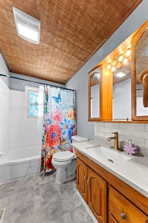 2535 S Park Ln, Florissant, MO 63031 - full bath with wooden ceiling, vanity, shower / bath combination with curtain, toilet, and decorative backsplash