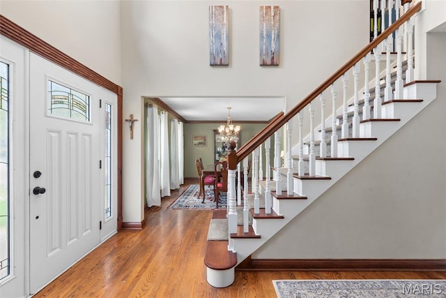 2854 Championship Blvd, Saint Louis, MO 63129 - entrance foyer featuring stairway, a chandelier, wood finished floors, baseboards, and a high ceiling
