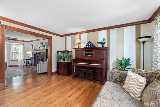 2854 Championship Blvd, Saint Louis, MO 63129 - living room featuring light wood-style floors, ornamental molding, a brick fireplace, and baseboards