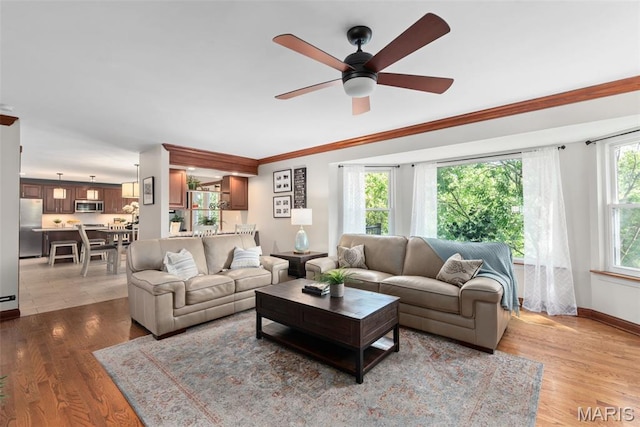 2854 Championship Blvd, Saint Louis, MO 63129 - living room featuring a ceiling fan, wood finished floors, baseboards, and crown molding