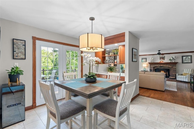 2854 Championship Blvd, Saint Louis, MO 63129 - dining area featuring ceiling fan, a fireplace, light tile patterned floors, and baseboards