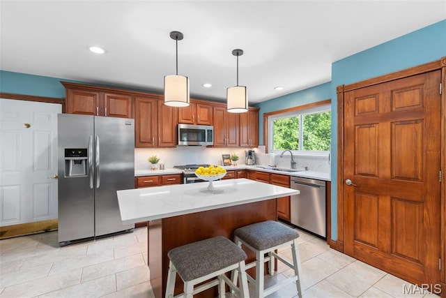 2854 Championship Blvd, Saint Louis, MO 63129 - kitchen featuring appliances with stainless steel finishes, a sink, light tile patterned floors, brown cabinets, and hanging light fixtures